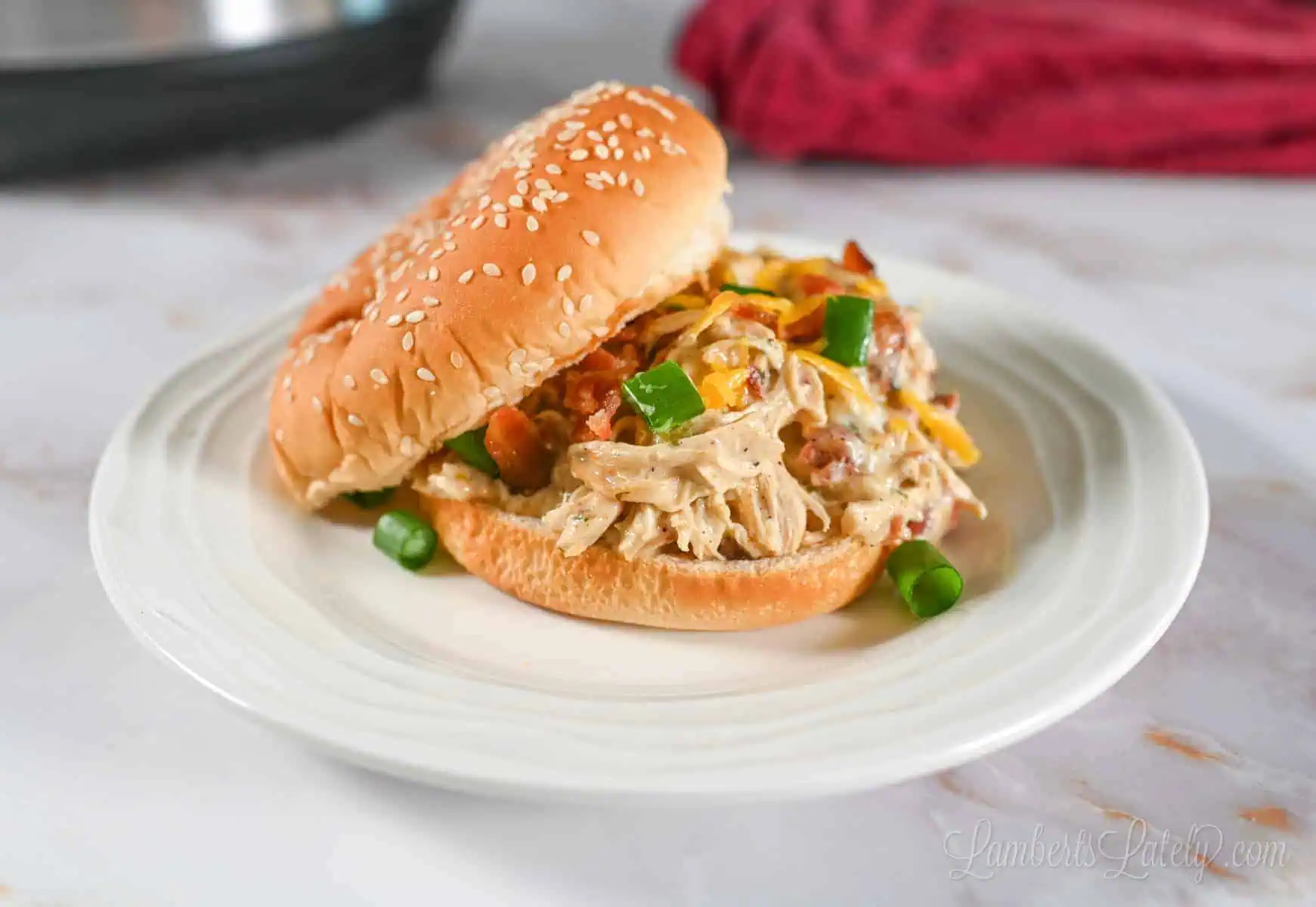 instant pot crack chicken on a sandwich bun, on a plate.