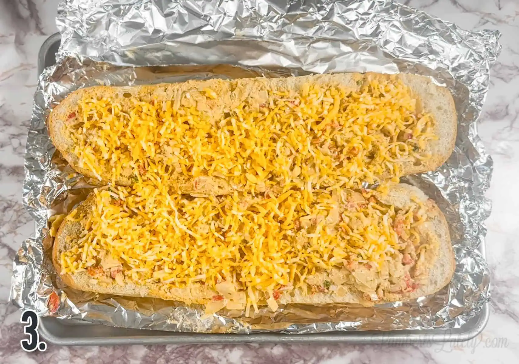 loaves of crawfish bread covered in unmelted cheese.