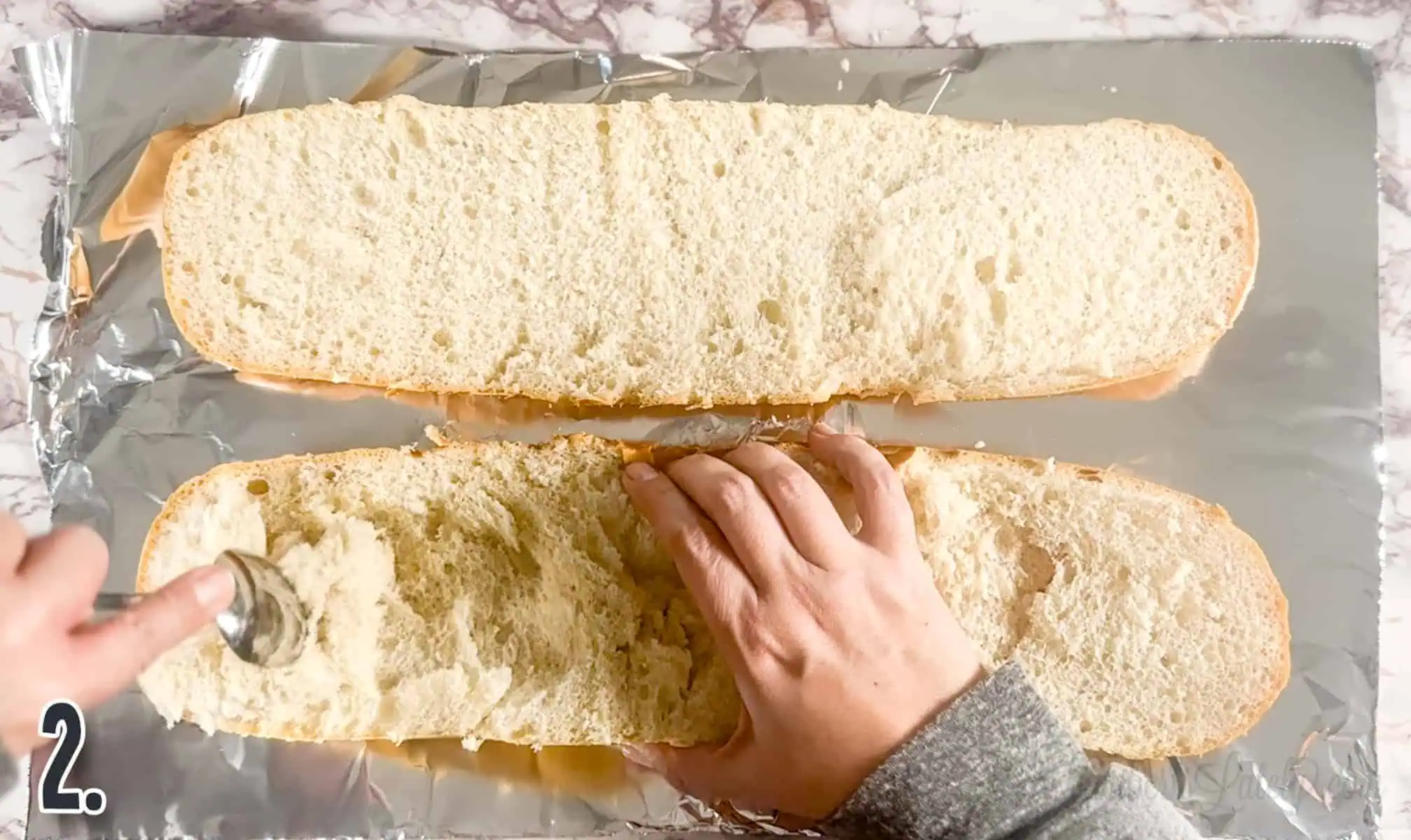 scraping the inside out of a loaf of french bread.