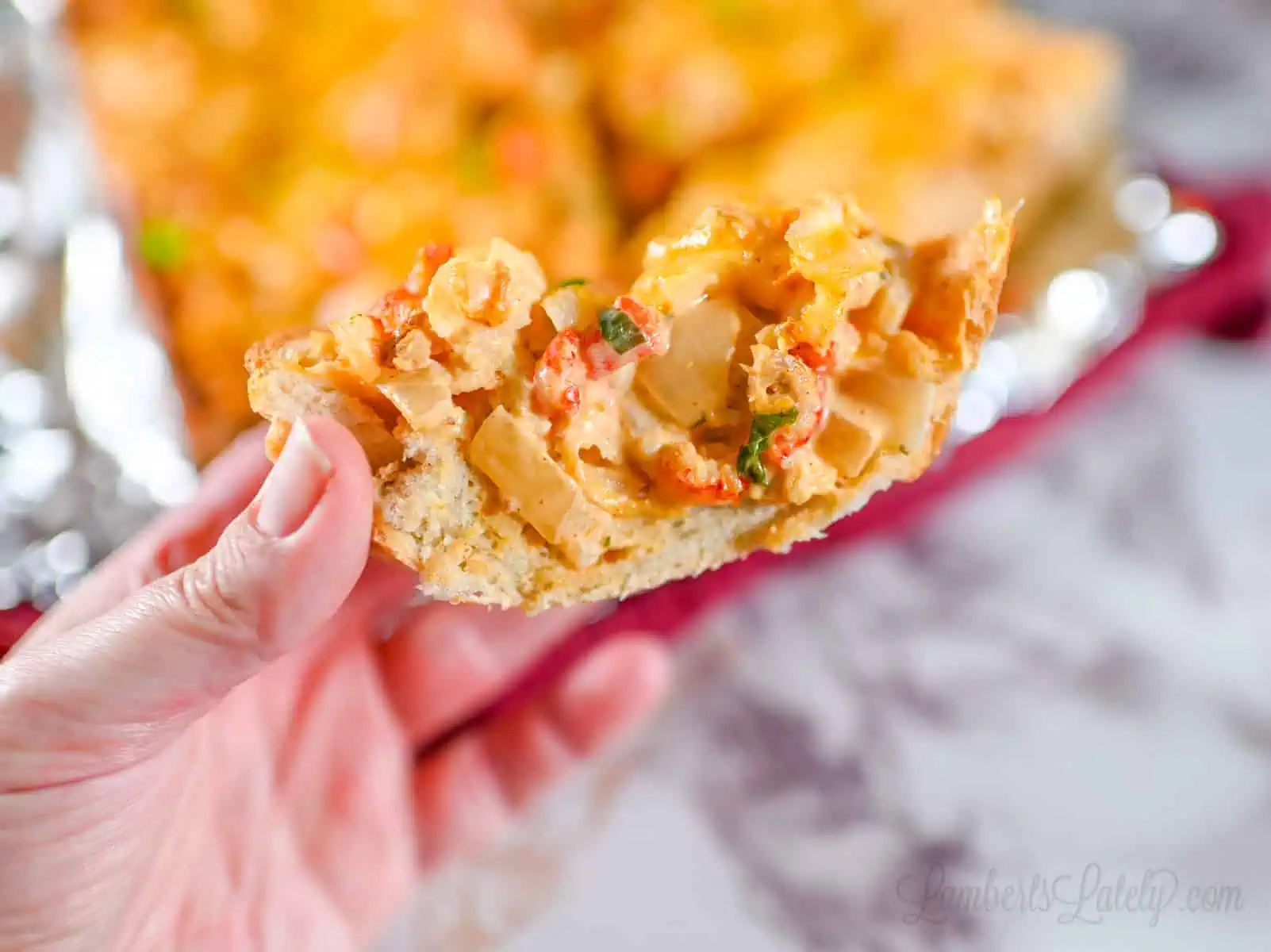holding a slice of crawfish bread.