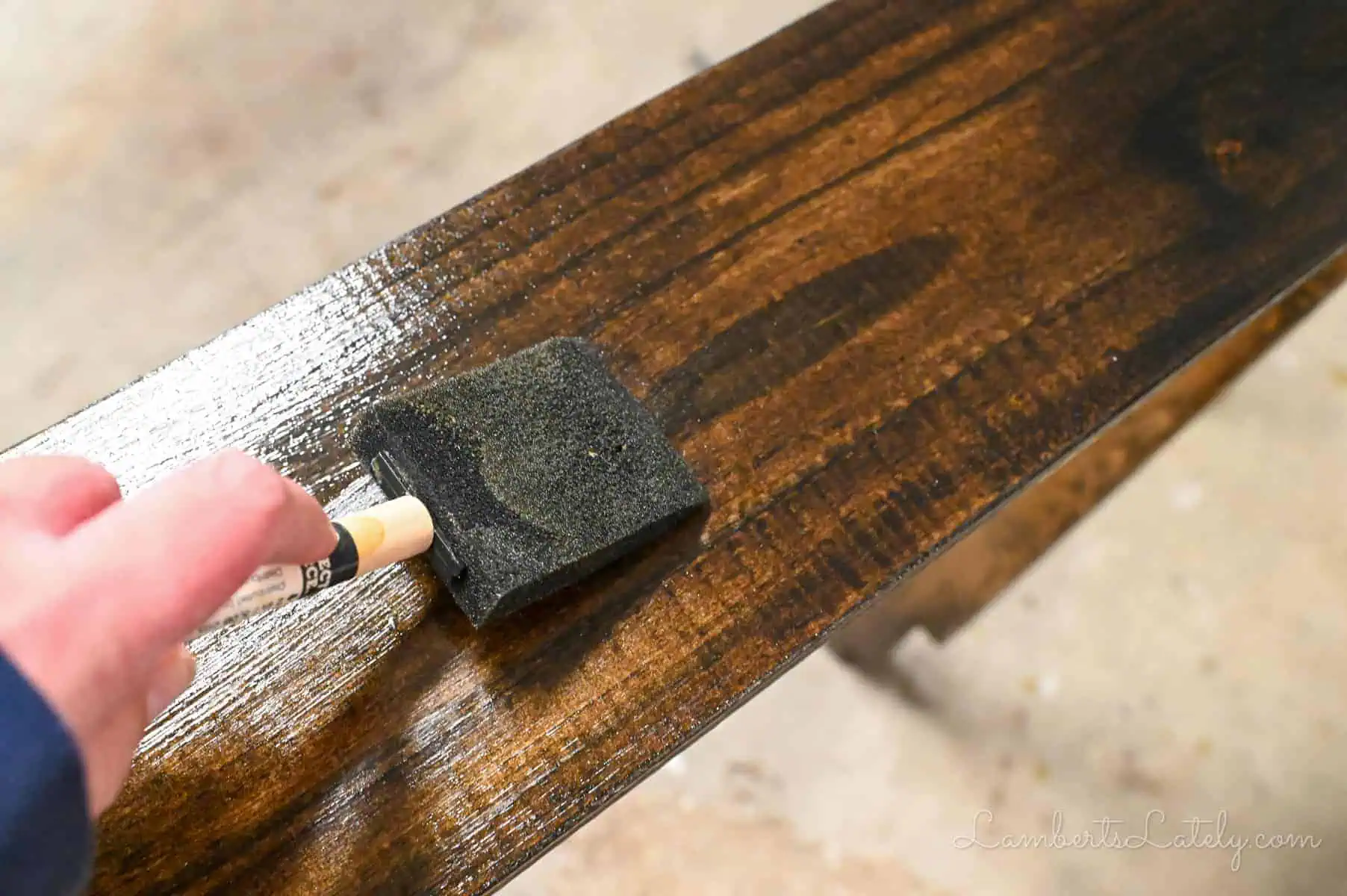 using a sponge brush to apply polyurethane.