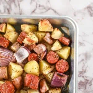 sausage, potatoes, and onion cooked on a sheet pan.