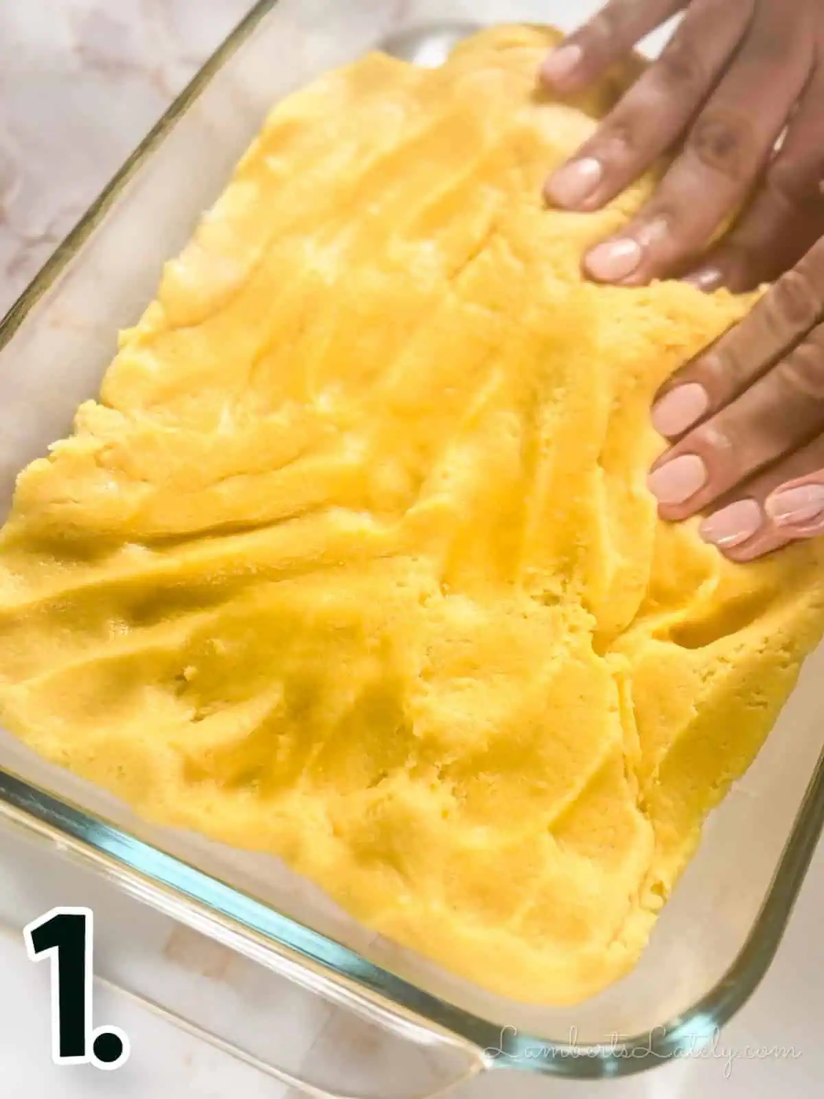pressing cake mixture into a glass baking dish.
