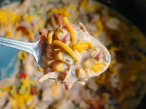 spoonful of crack chicken chili above a crock pot.