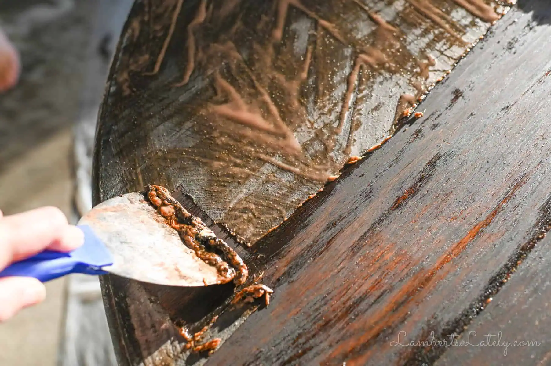 using a paint scraper to take off stripping gel.