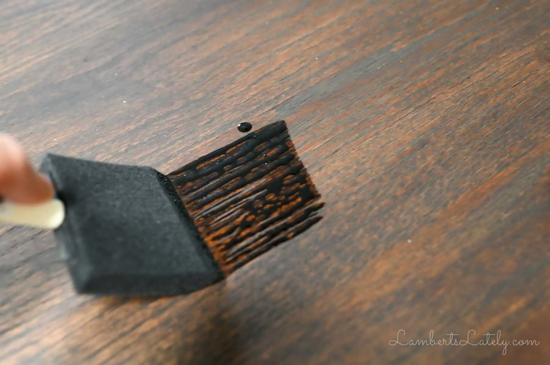 applying stain to a table with a sponge brush.