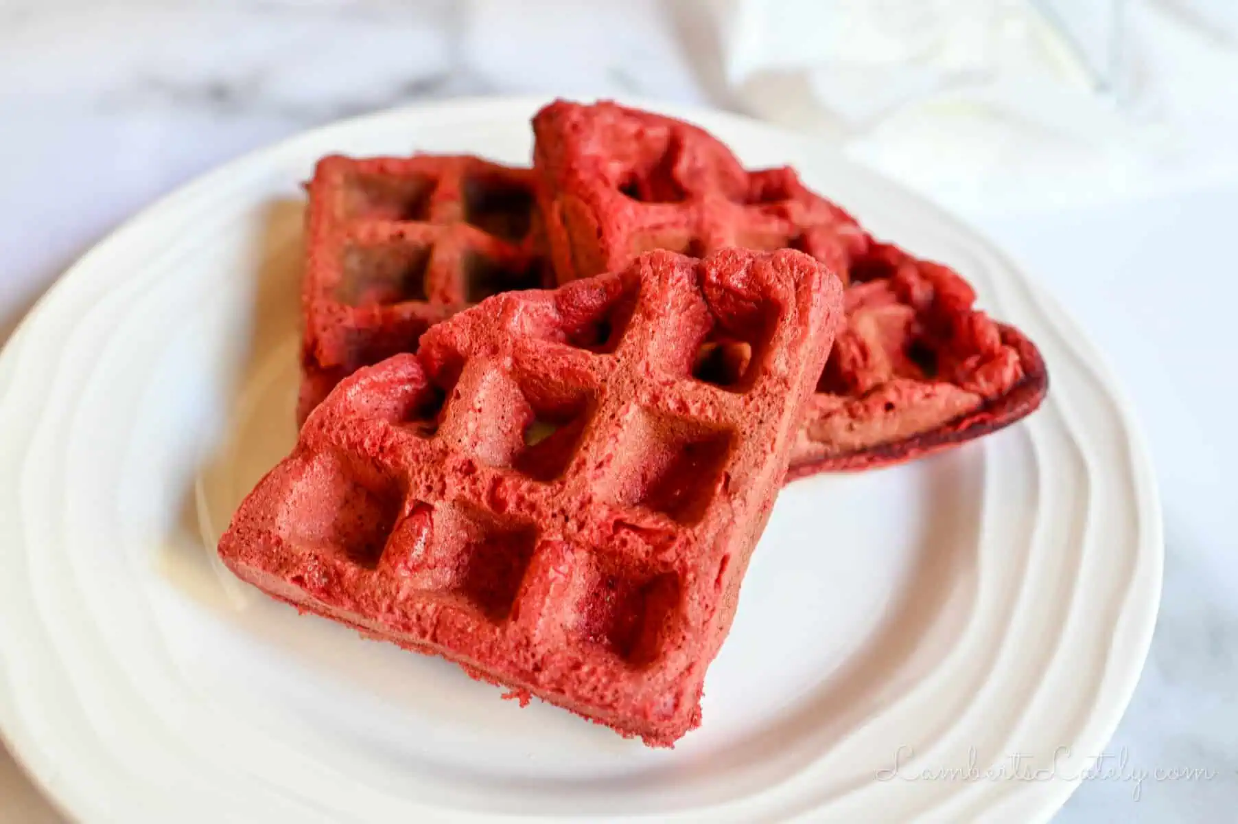 red velvet waffles on a plate.