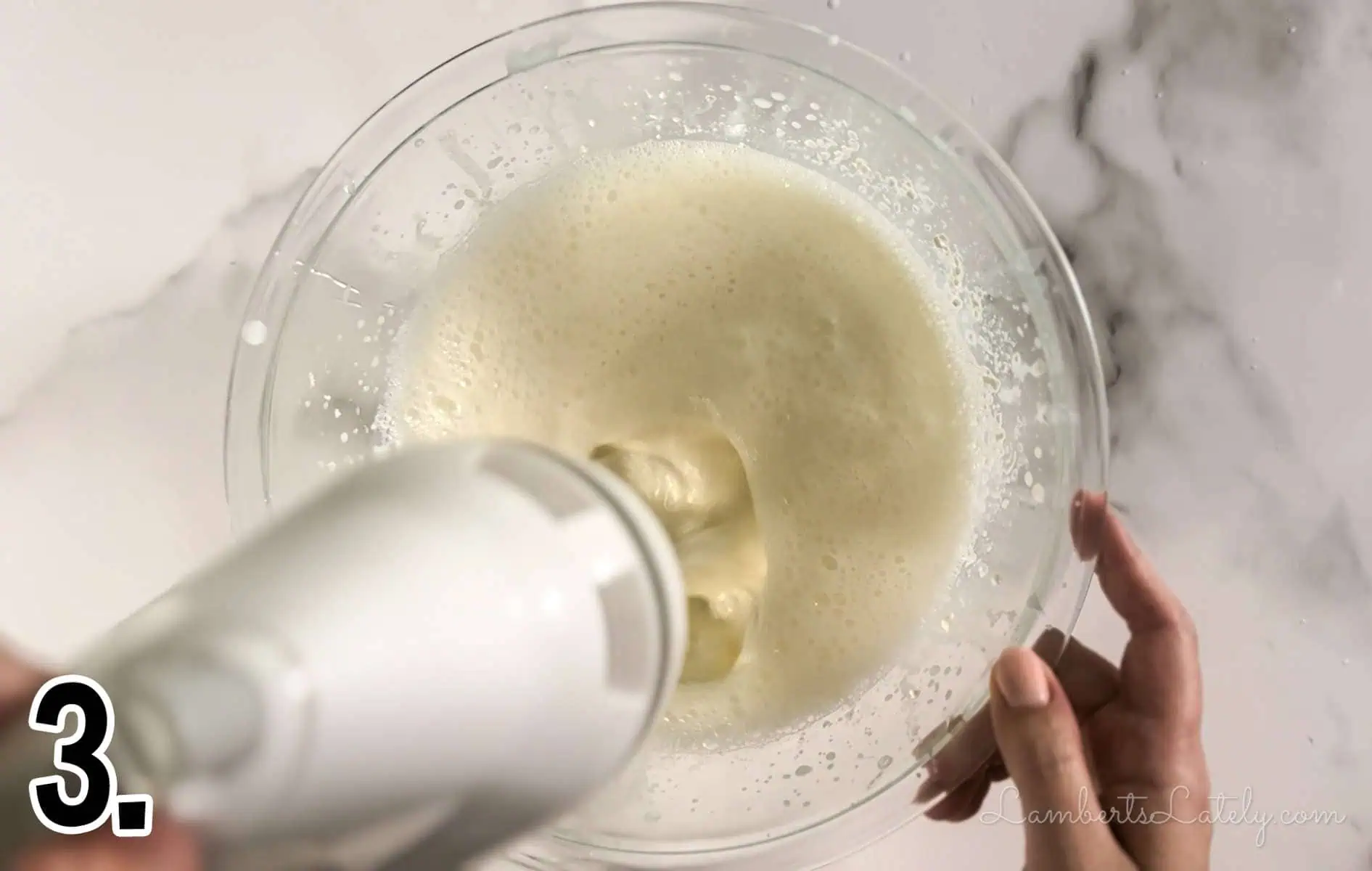 mixing cream cheese glaze with a hand mixer.