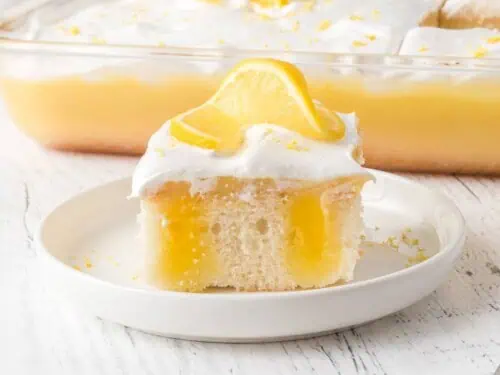 piece of lemon marshmallow poke cake on a plate.