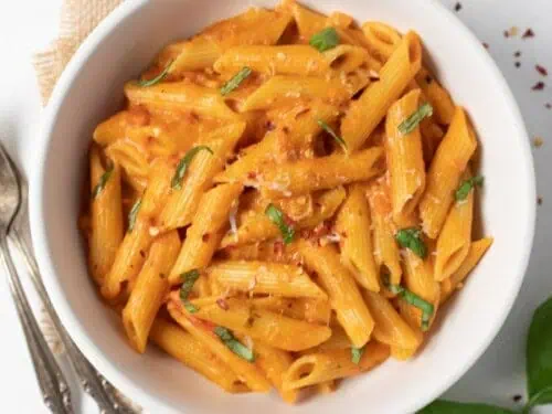 penne alla vodka in a bowl, next to two forks.