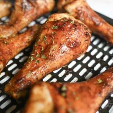 piece of barbecue chicken on an air fryer pan.
