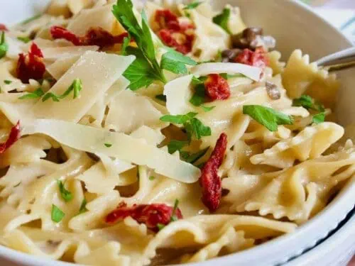 bow tie pasta with sun-dried tomatoes and parmesan in a bowl.