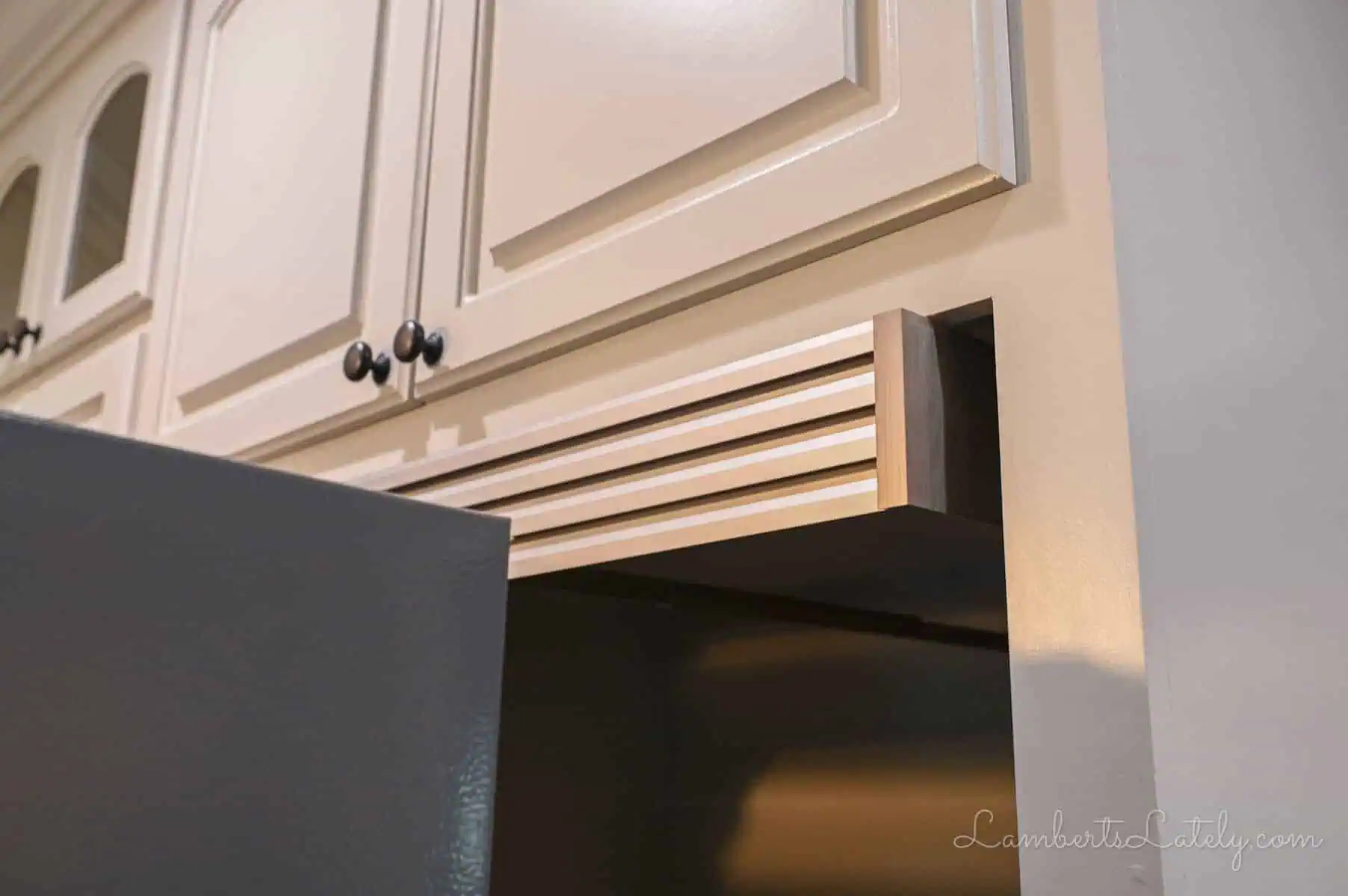 top piece of a fridge trim kit installed in casing.