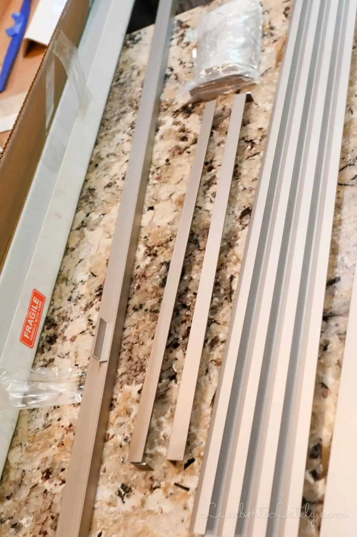 pieces to a refrigerator trim kit on a kitchen counter.