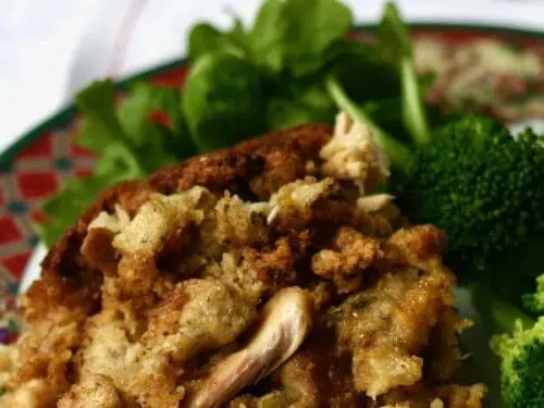 chicken and dressing on a plate with green lettuce.