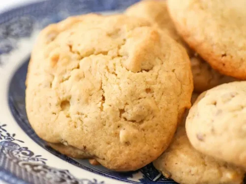orange pecan cookies stacked on a plate.