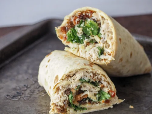chicken ceasar salad wraps stacked on a plate.