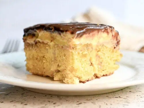 piece of boston creme poke cake on a plate.