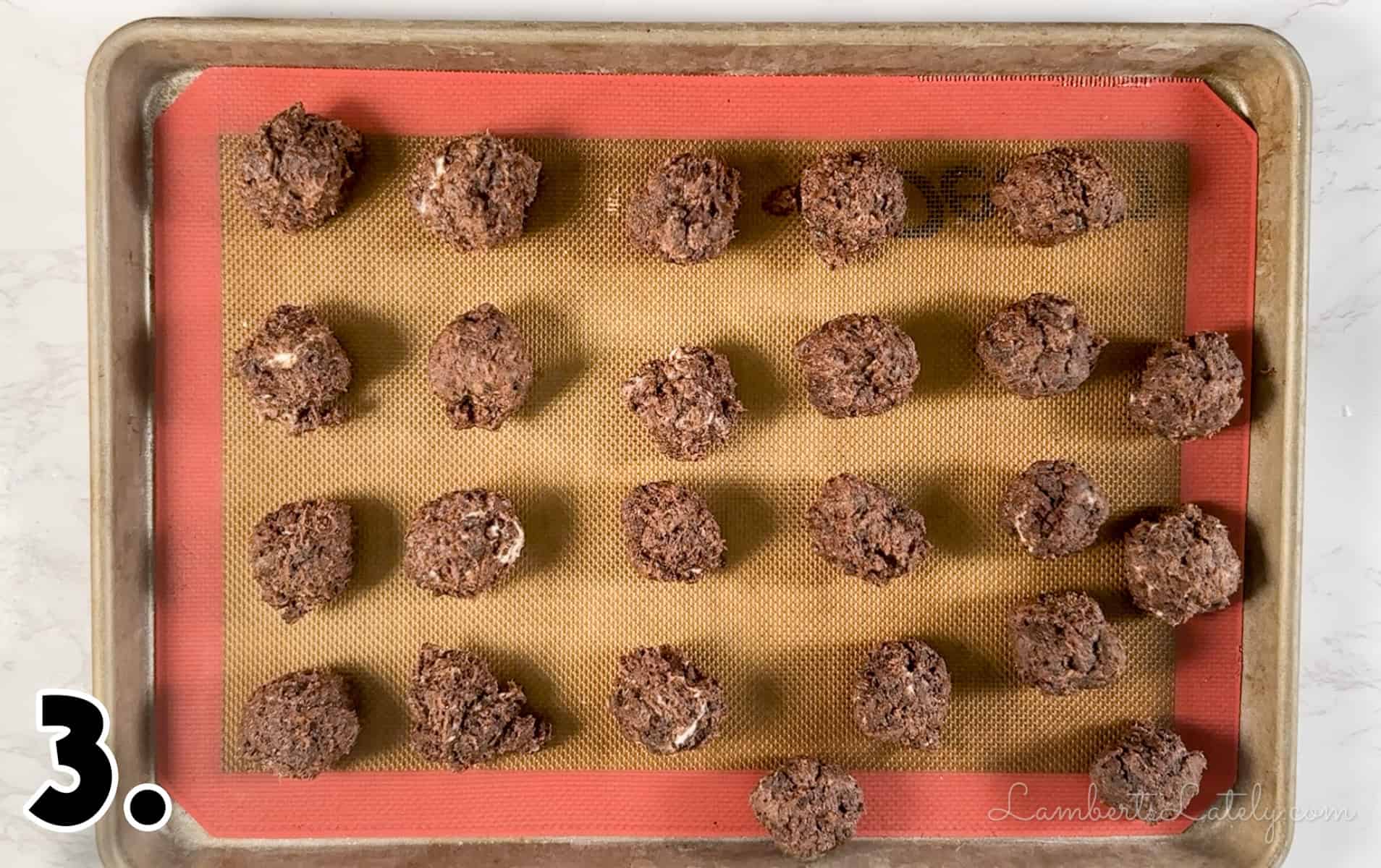 rolled brownie cake balls on a baking sheet.