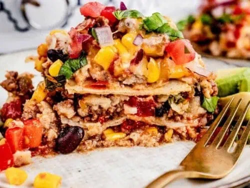 mexican casserole on a plate, with a fork.