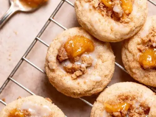 peach cobbler cookies on a baking rack, next to a spoon of peach pie filling.