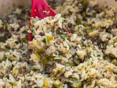 a spoon in a baking dish of dirty rice.