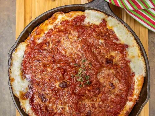 deep dish pizza in a cast iron skillet.