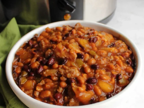 bowl of baked beans in front of a crock pot.