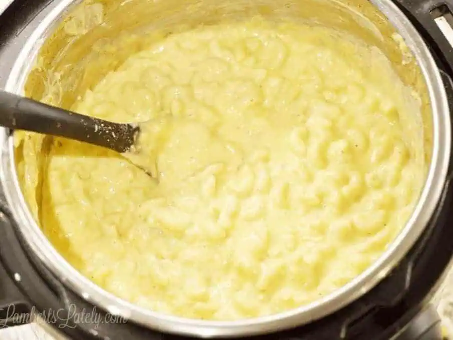 mac and cheese being stirred in an Instant Pot.