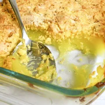 a spoon in a baking dish of lemon dump cake.