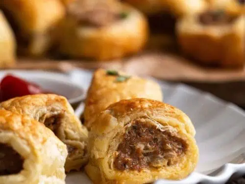 sausage rolls cut open on a plate.