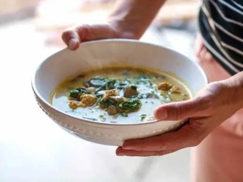 holding a bowl of pumpkin sausage soup.