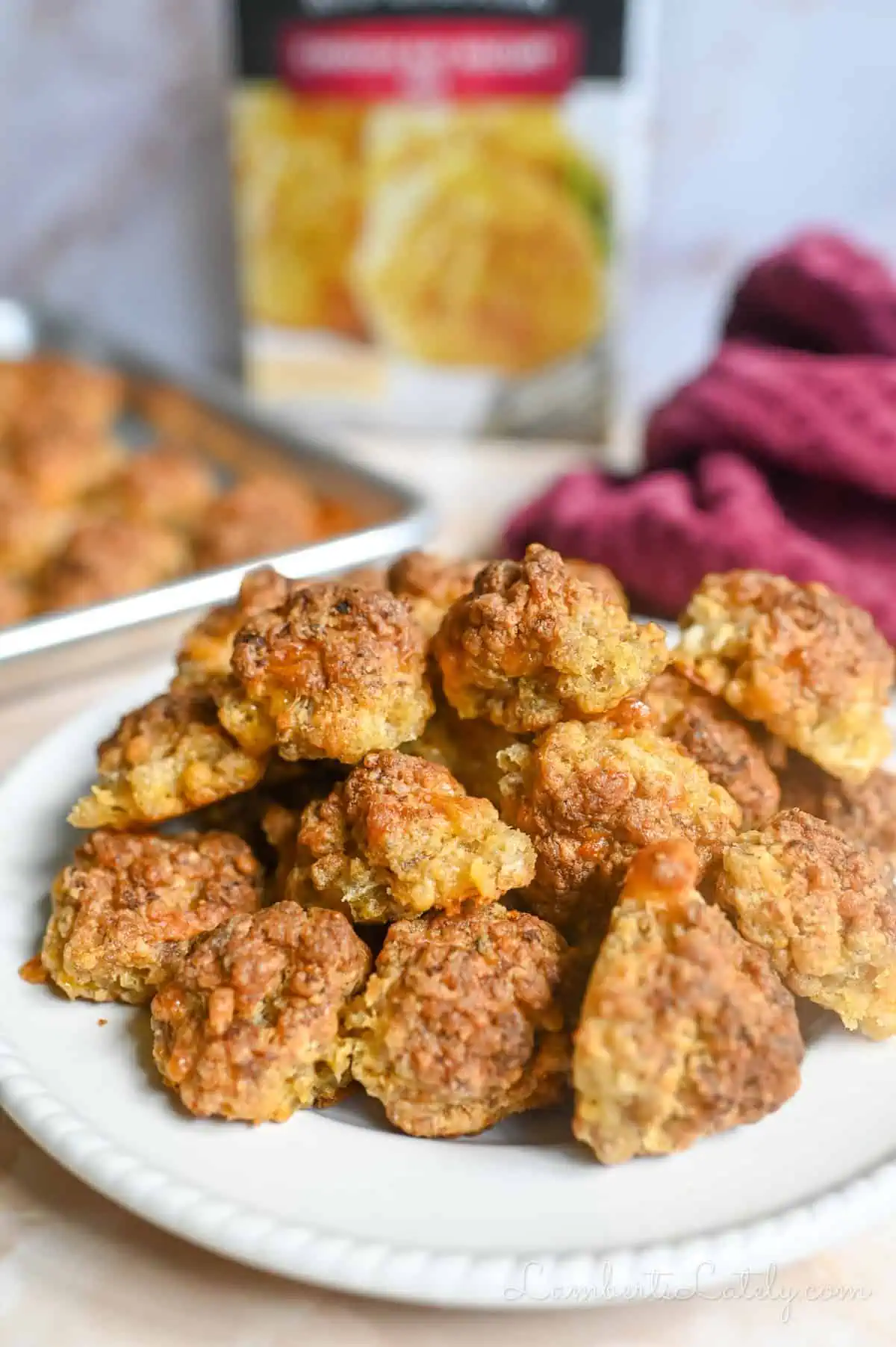sausage balls on a plate in front of a box of red lobster chedday bay biscuit mix.