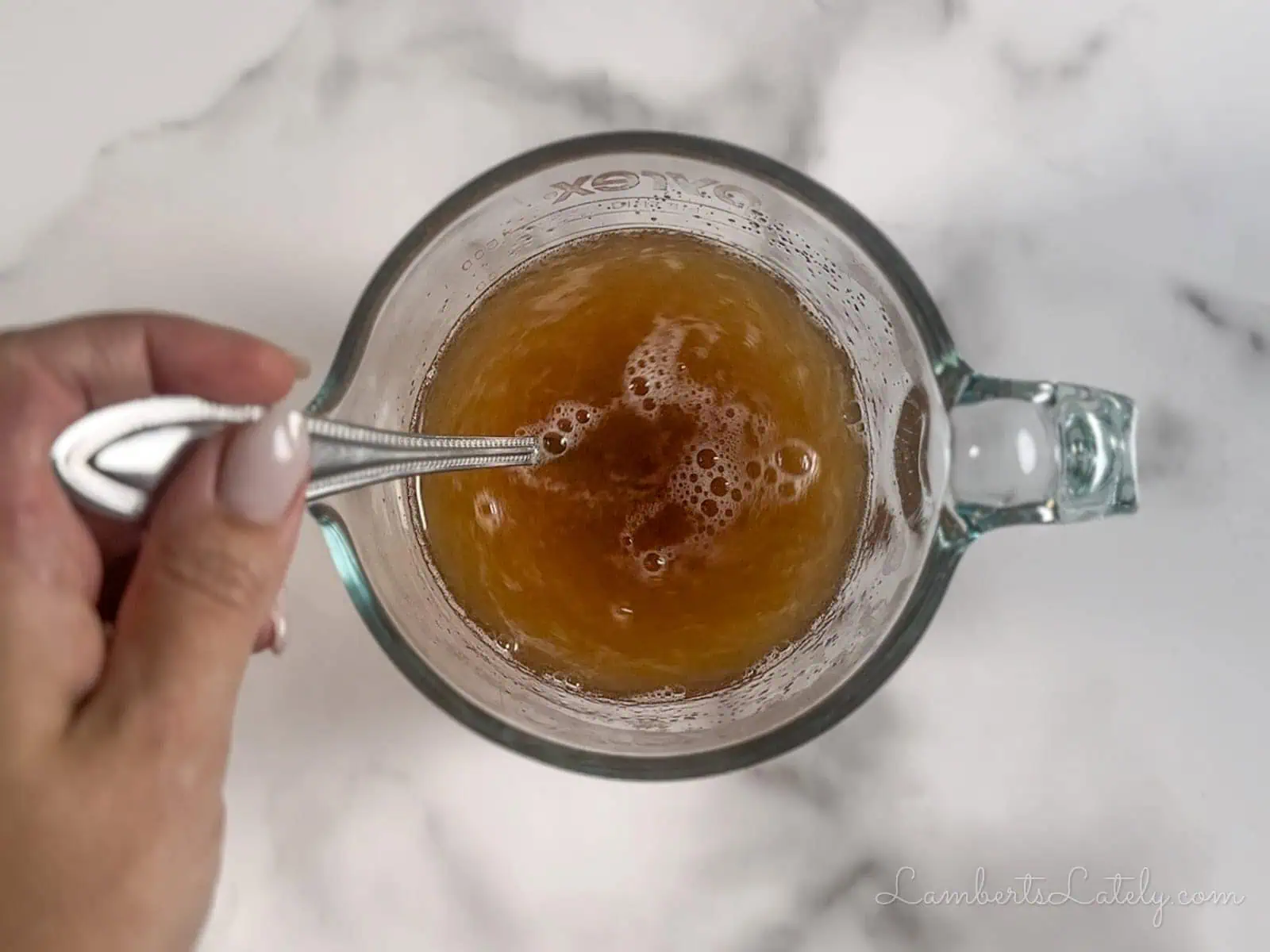 stirring hot water and brown sugar in a measuring cup.