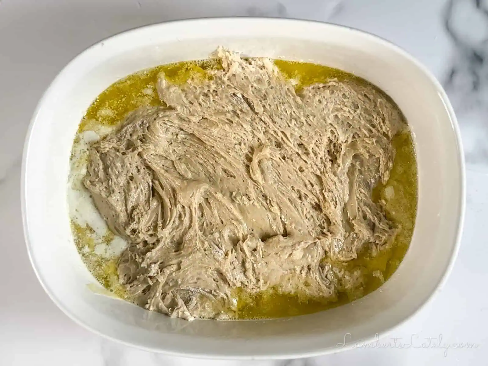 cake batter over butter in a casserole dish.