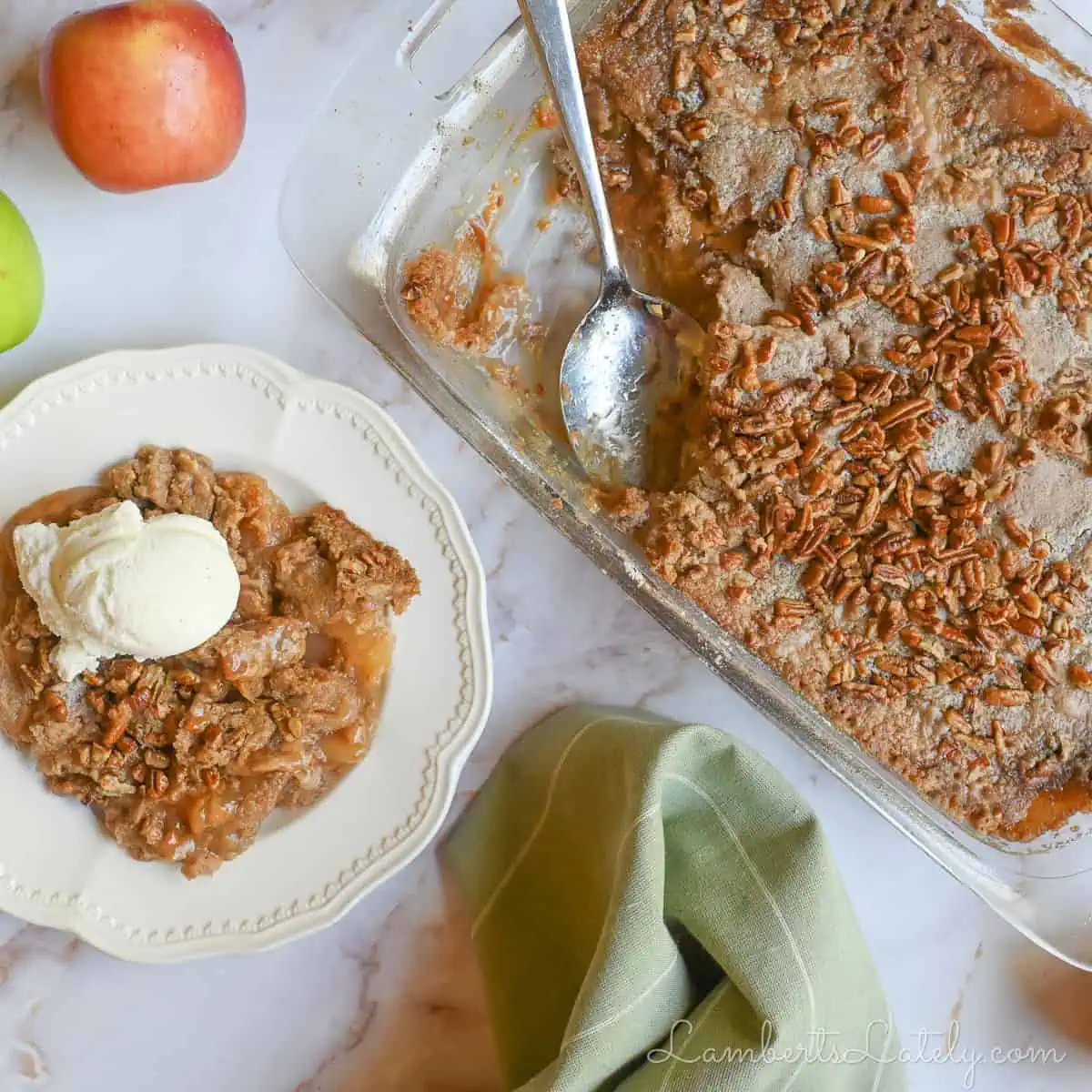 caramel apple dump cake in a baking dish, with serving topped with ice cream next to it.