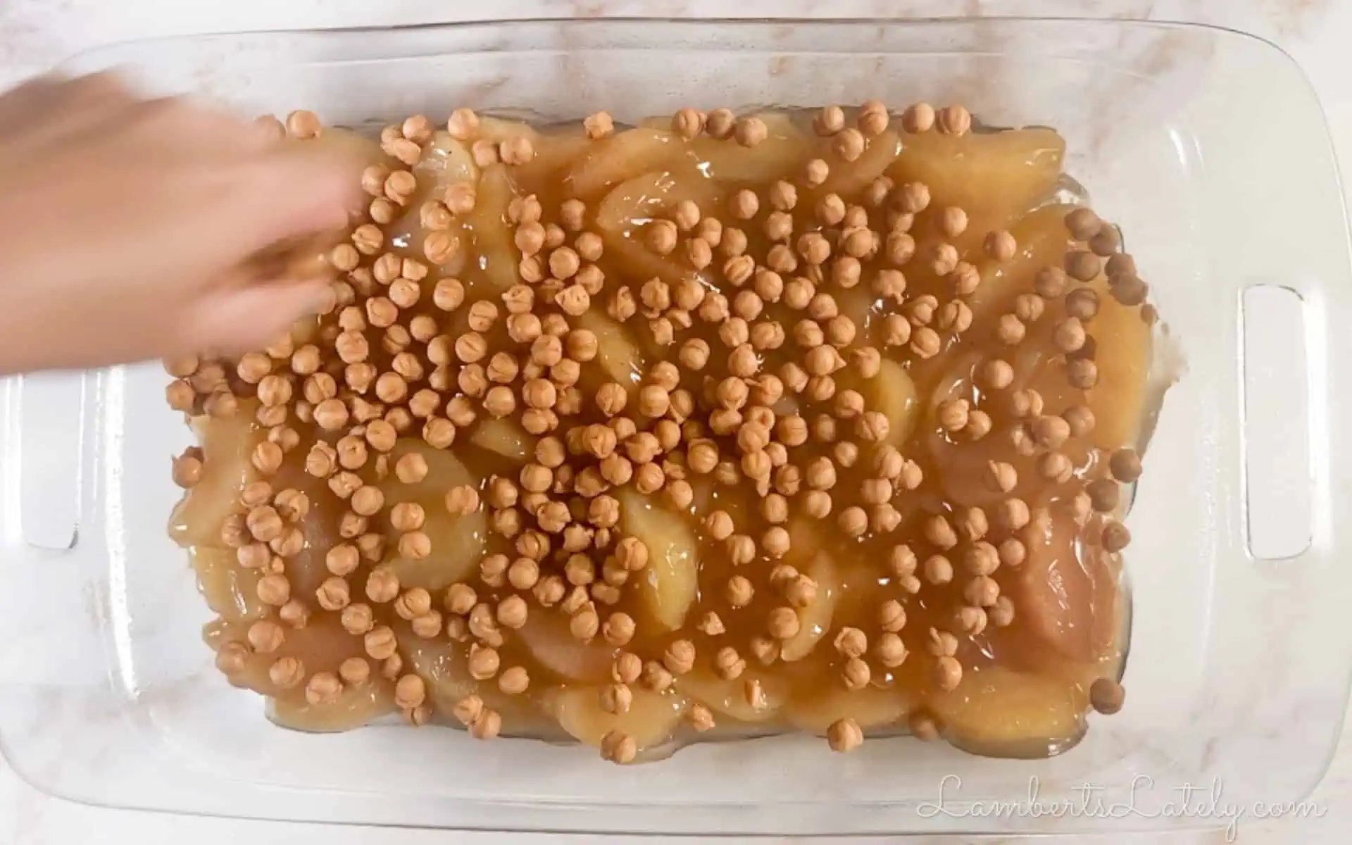 apple pie filling and caramel bits in a baking dish.