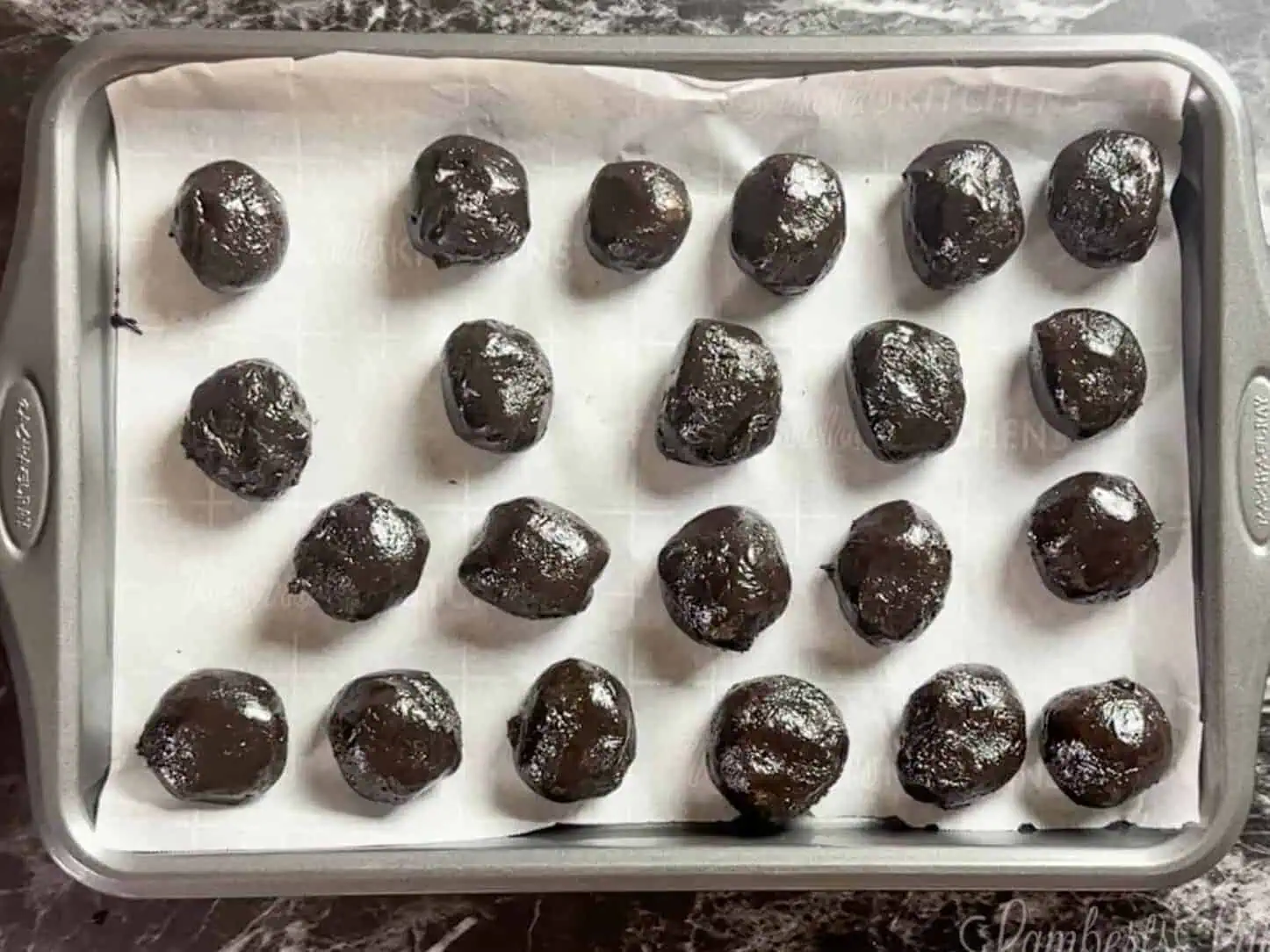 oreo balls on a cookie sheet lined with parchment paper.