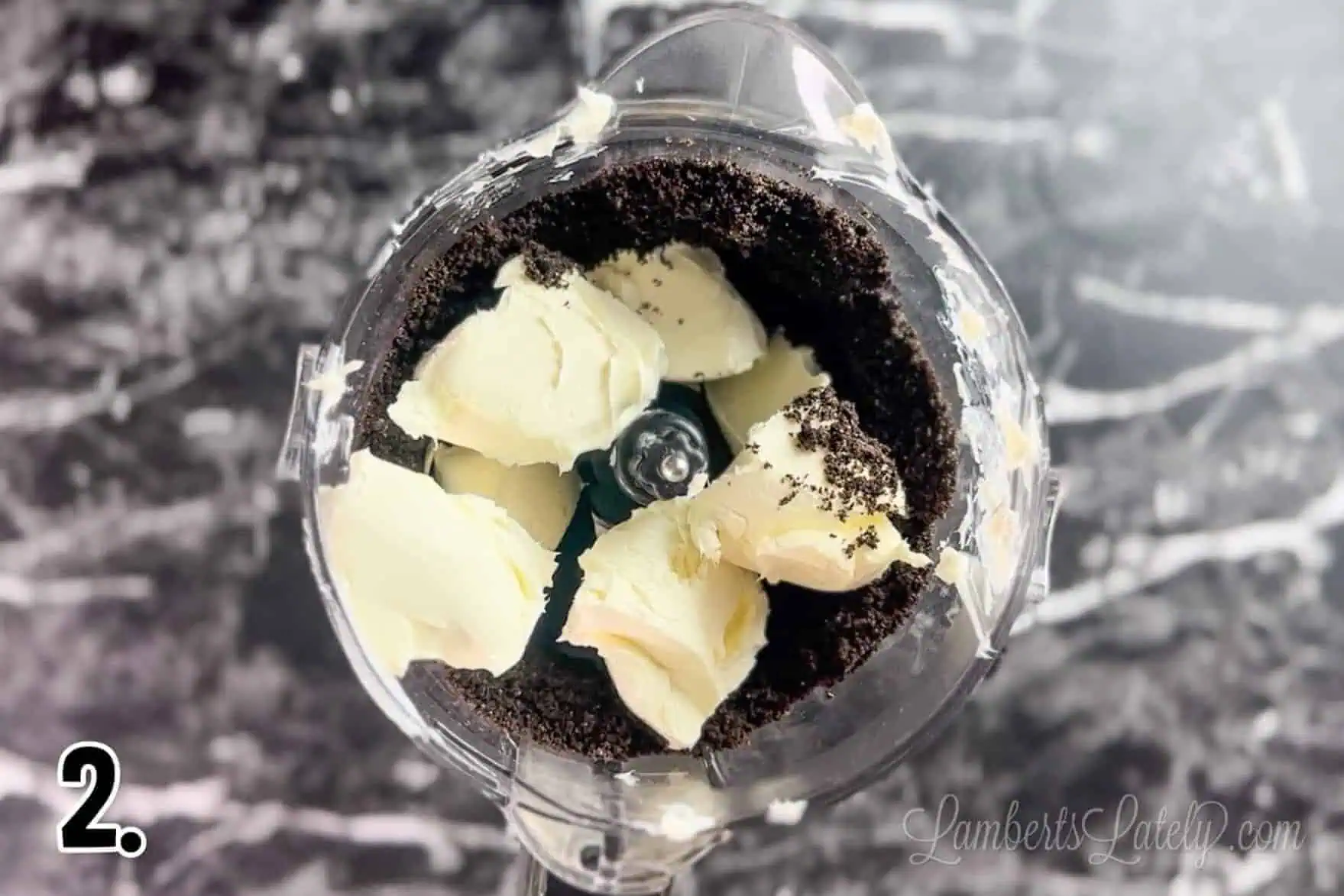 cream cheese on top of oreo crumbs in a food processor.