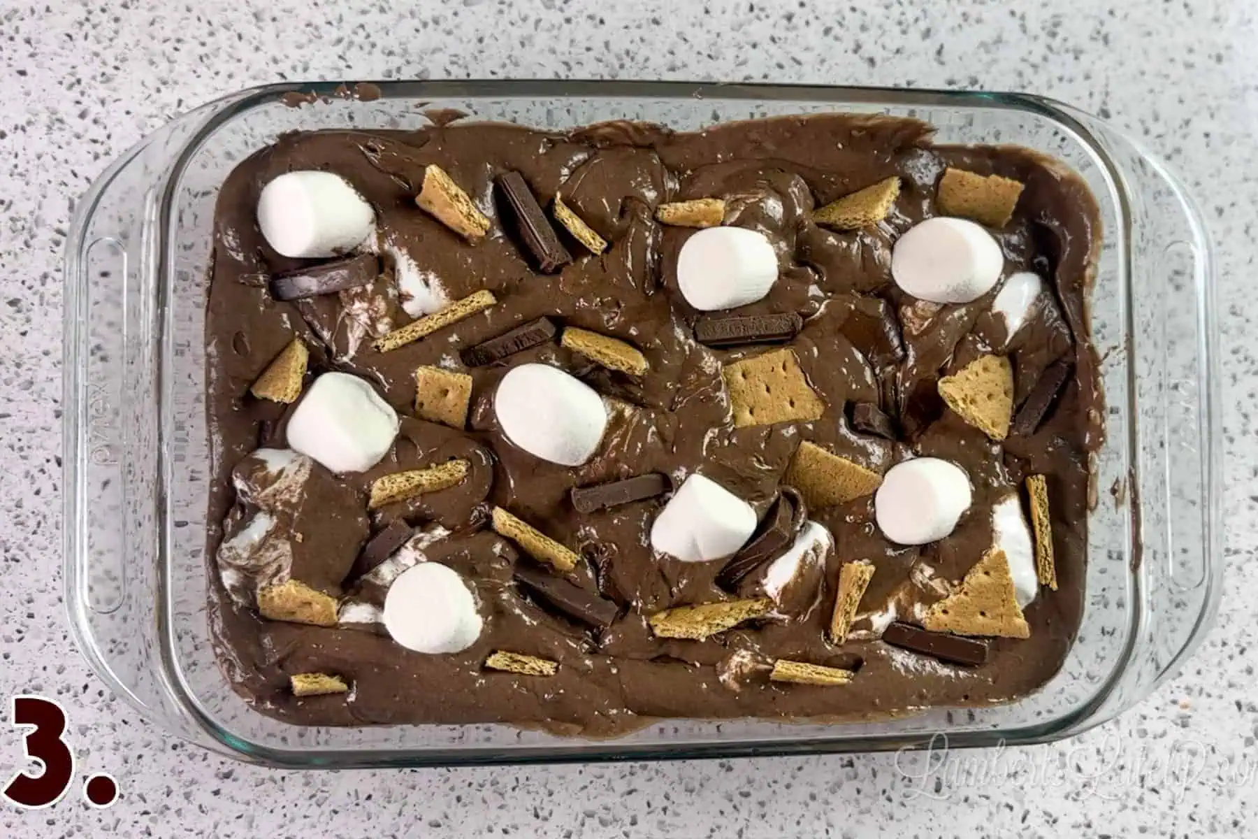 marshmallows, graham crackers, and chocolate bars pressed into cake batter mixture.