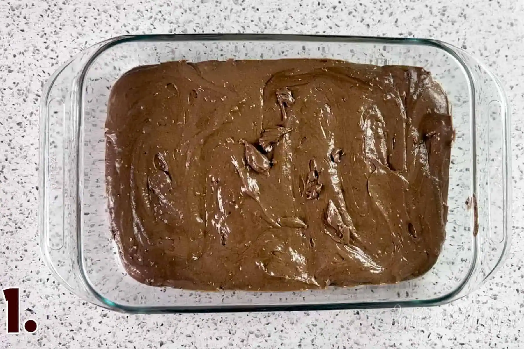 chocolate cake batter in a glass baking dish.