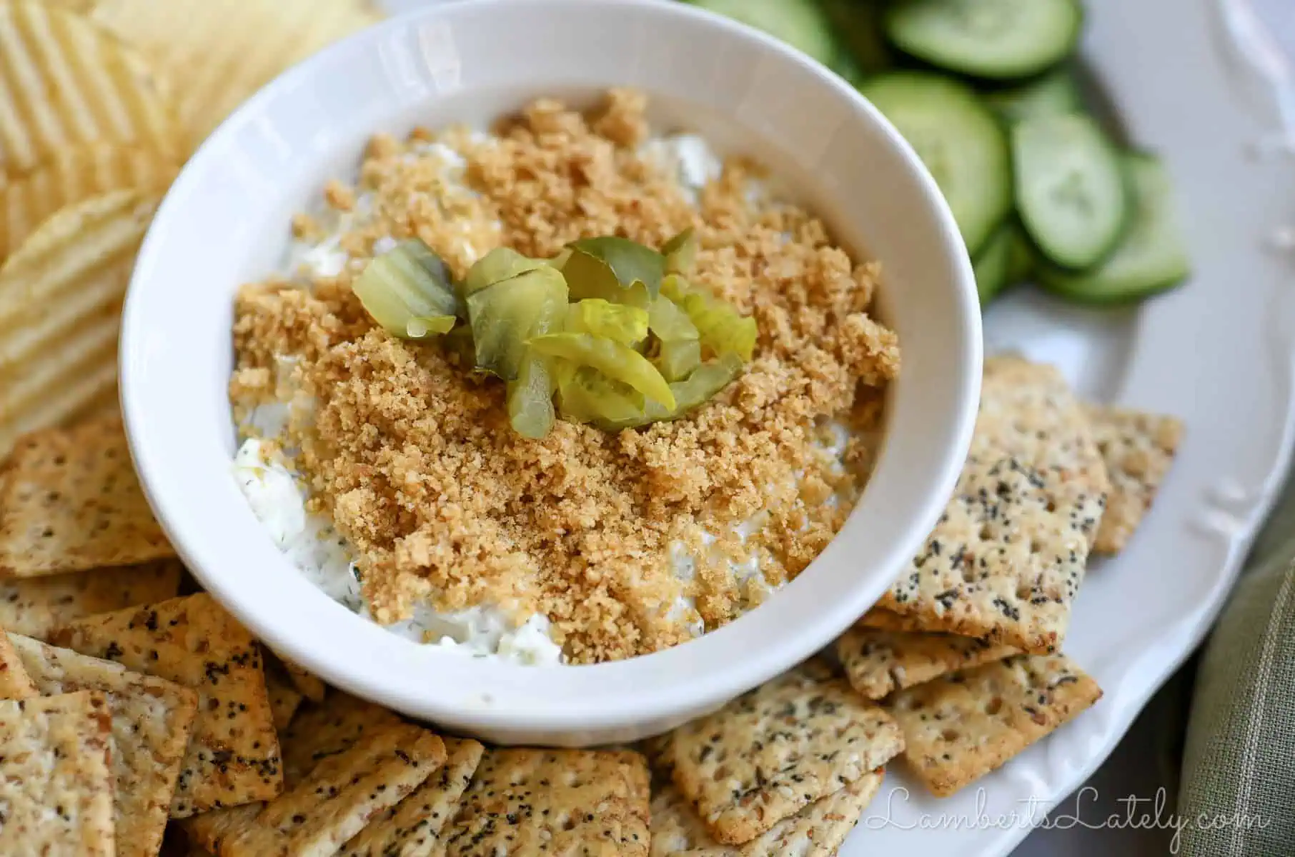 fried pickle dip in a serving dish, surrounded by dippers.