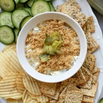 fried pickle dip surrounded by dippers on a platter.