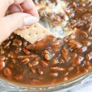 dipping a graham cracker in pecan pie dip.