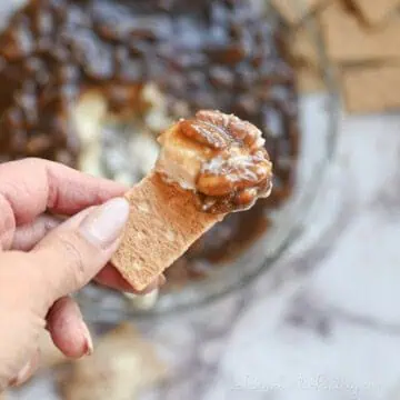holding pecan pie dip on a graham cracker.
