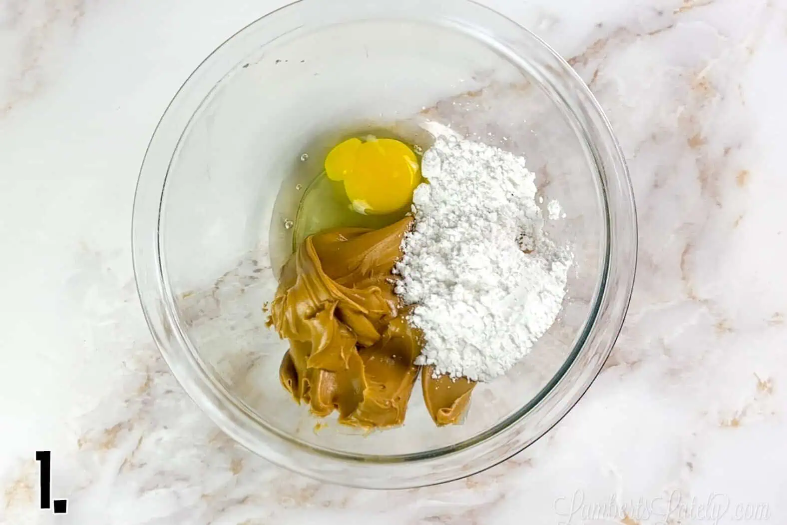ingredients for peanut butter cookies in a clear glass bowl.