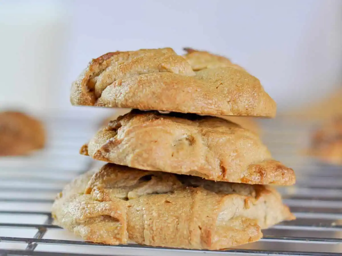 three peanut butter cookies stacked on a baking rack.