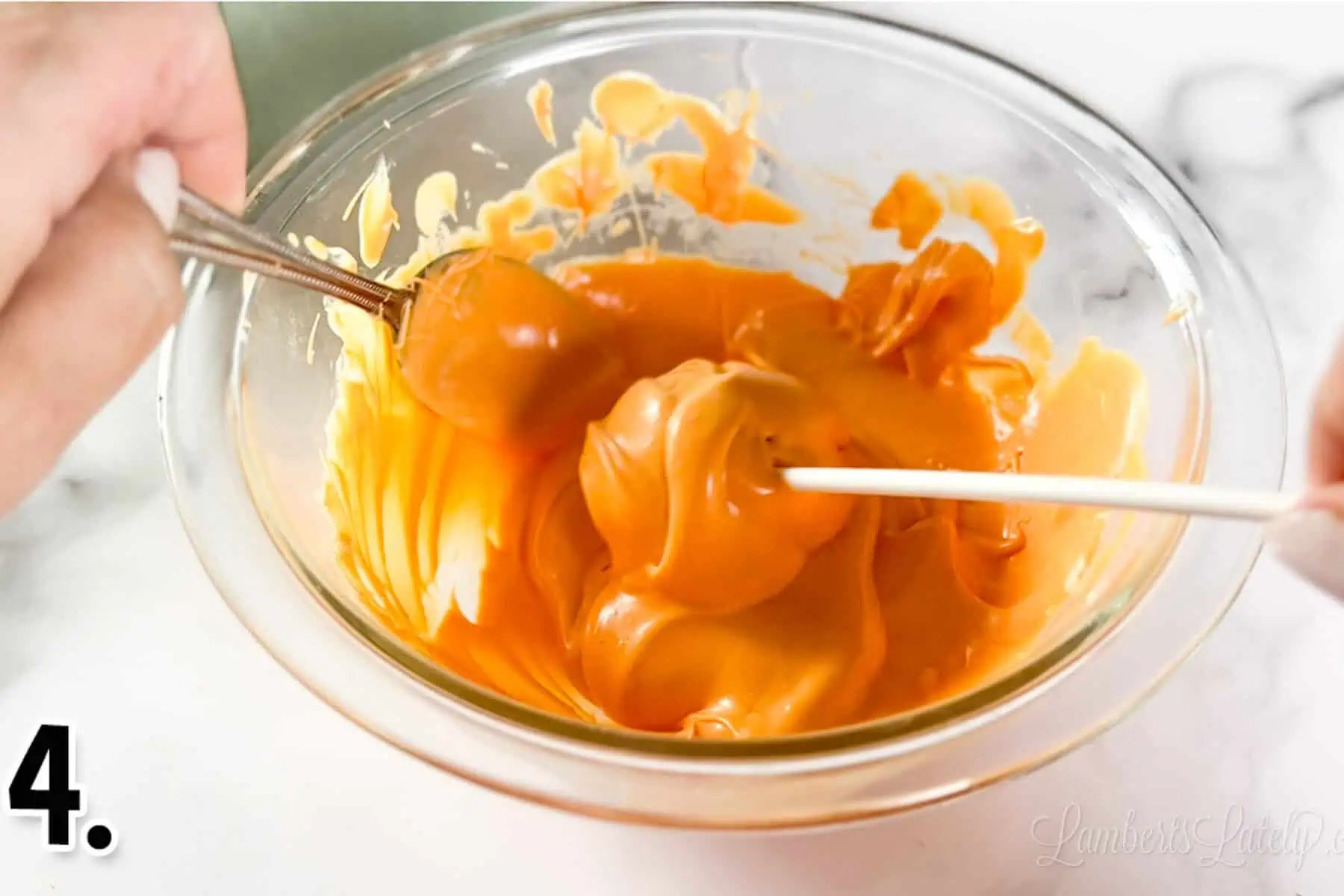 dipping cake pop in orange melted candy.