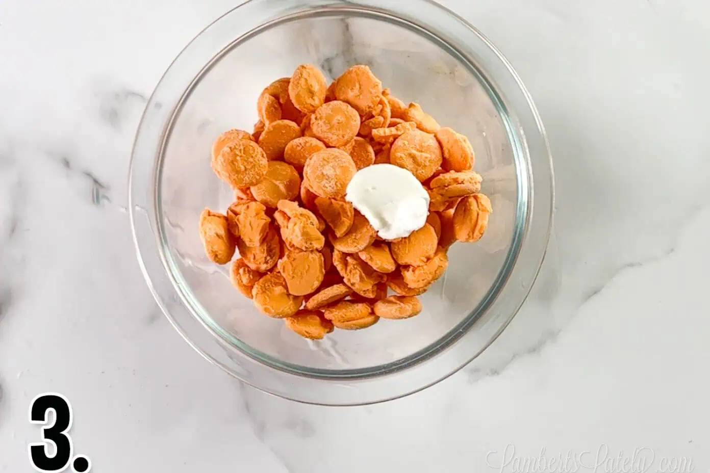 orange candy melts and crisco in a glass bowl.
