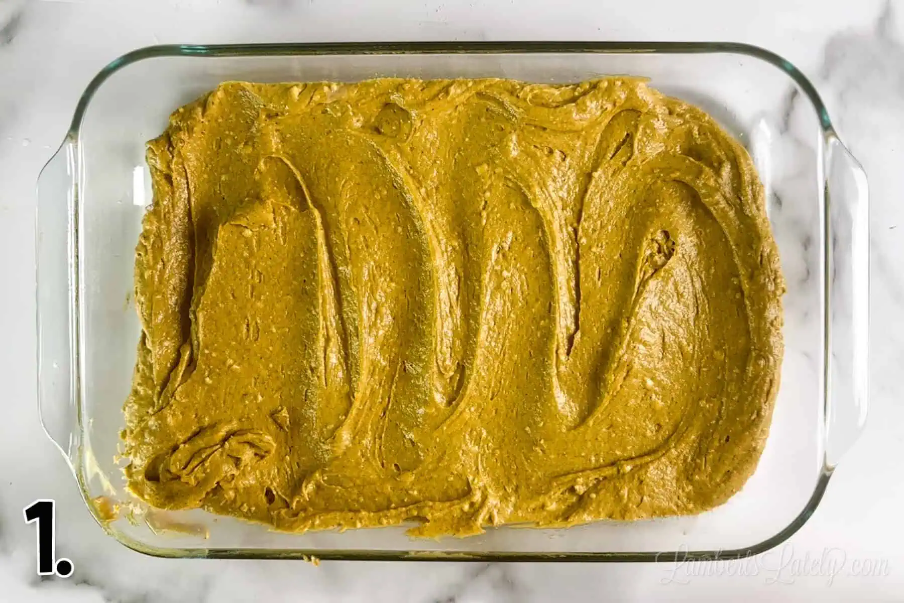 pumpkin cake base batter spread in a baking dish.